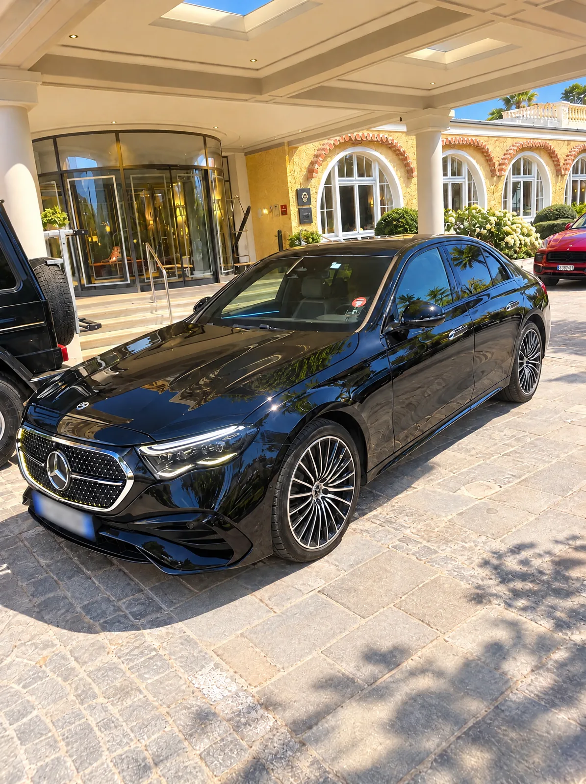 Mercedes Classe E noire devant l’entrée d’un hôtel de luxe, chauffeur privé VTC Optimum Transfert à Marseille