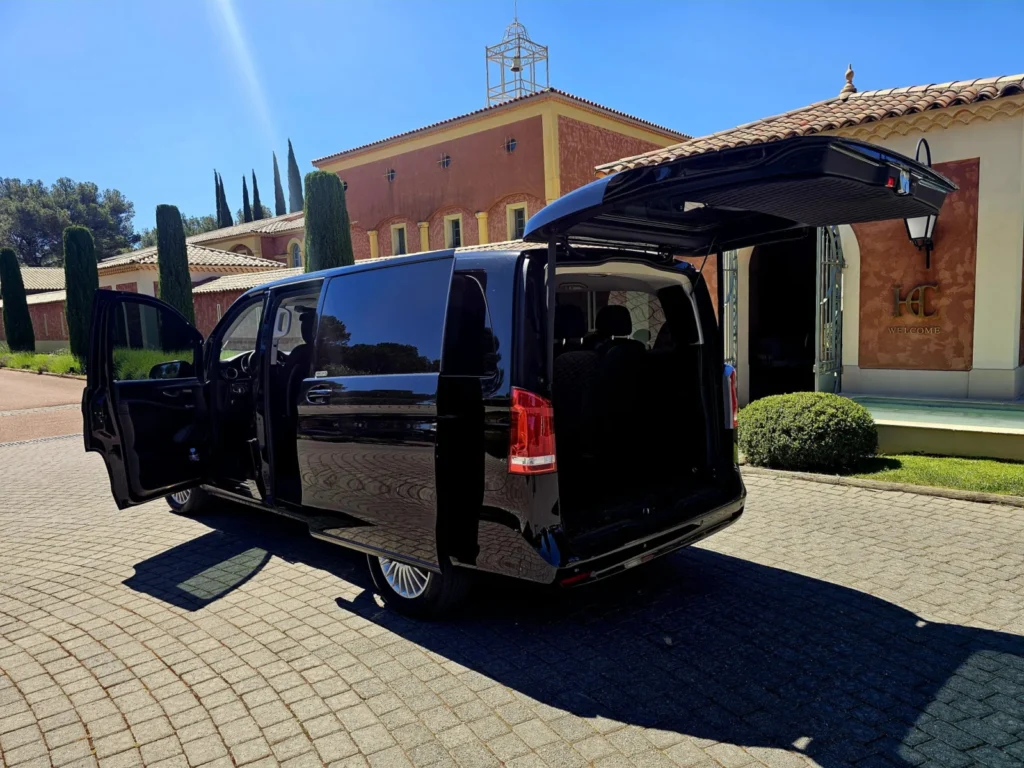 Van Mercedes-Benz EQV noir, portes et coffre ouverts, devant un hôtel en Provence