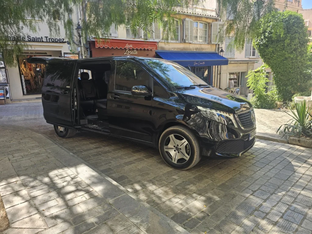 Van Mercedes-Benz EQV noir, portière coulissante ouverte, dans une rue pavée de Saint-Tropez